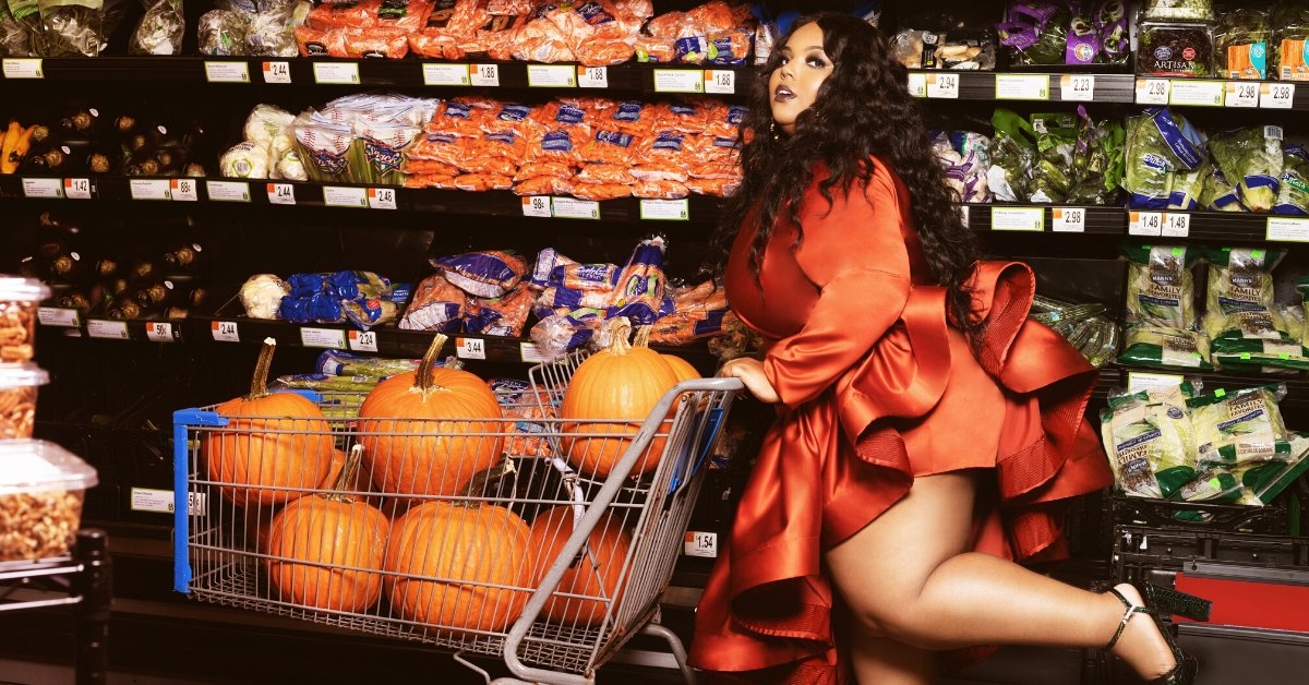A girl wearing red dress and shopping groceries with pumpkins in her shopping cart